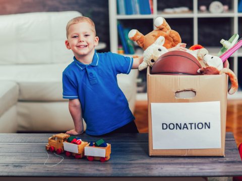 Boy taking donation box full with stuff for donate