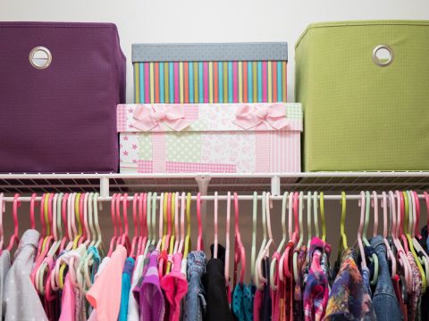 young girl's closet neatly organized with bins and boxes.