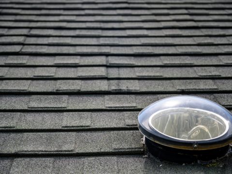 Dome shaped solar tube skylight on asphalt shingle roof